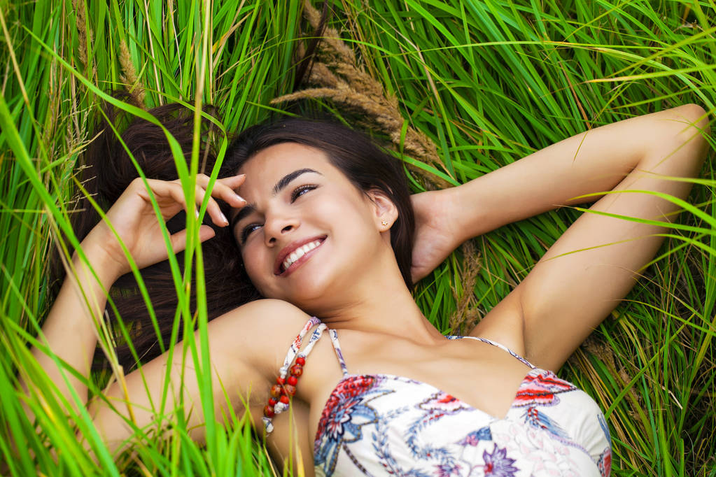 Femme heureuse se reposant et jour couché sur l'herbe verte
 - Photo, image