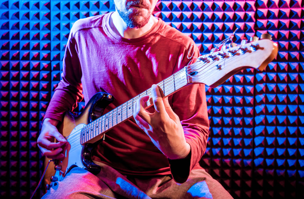 Genç adam gitar ses kayıt stüdyosu içinde oynamaya. Modern arka plan - Fotoğraf, Görsel