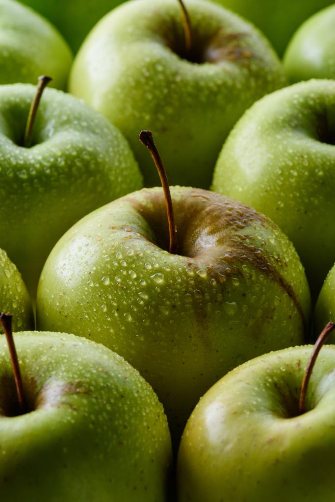 新鮮な緑のリンゴを背景に水滴のビューをクローズ アップ - 写真・画像
