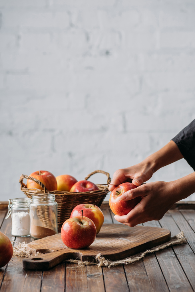 partial view of woman peeling apple with knife - Photo, Image