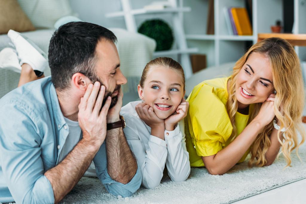 glückliche junge Familie liegt zu Hause zusammen auf dem Boden - Foto, Bild