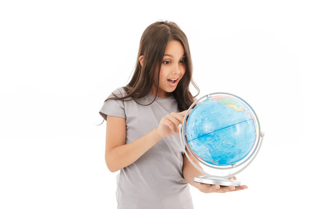 Aranyos lány áll elszigetelt fehér háttér gazdaság globe-fotó. - Fotó, kép