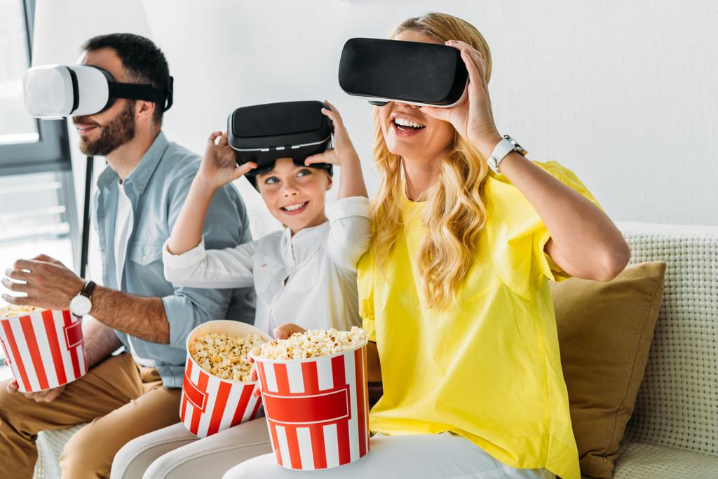 boldog fiatal család virtuális valóság fejhallgatók vödör a pattogatott kukorica - Fotó, kép