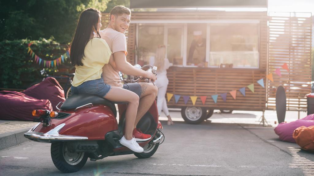 boldog pár ül a motorkerékpár élelmiszer-kamion utca közelében - Fotó, kép
