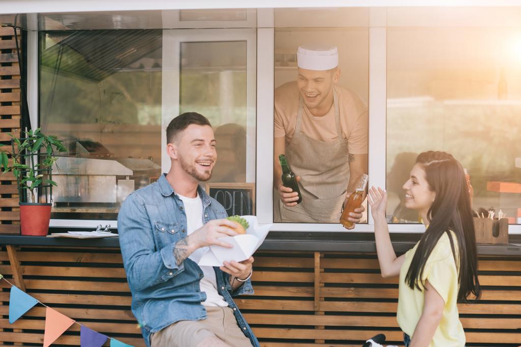 mosolyogva chef rendelés adva a vásárlók élelmiszer-teherautó - Fotó, kép
