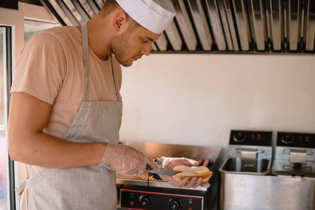chef preparando hod dog en camión de comida y corte de pan
 - Foto, Imagen