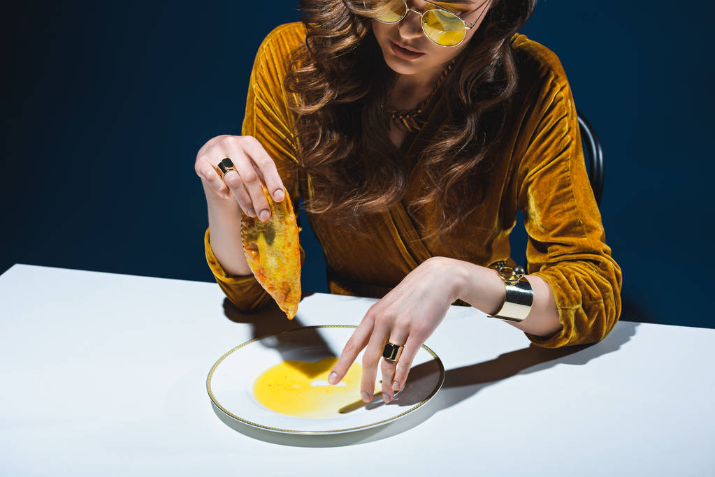 Módní žena s zdravotně závadné maso pečivo sedí u stolu s modré pozadí - Fotografie, Obrázek