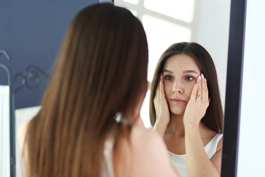 Jovem mulher olhando-se reflexão no espelho em casa
. - Foto, Imagem
