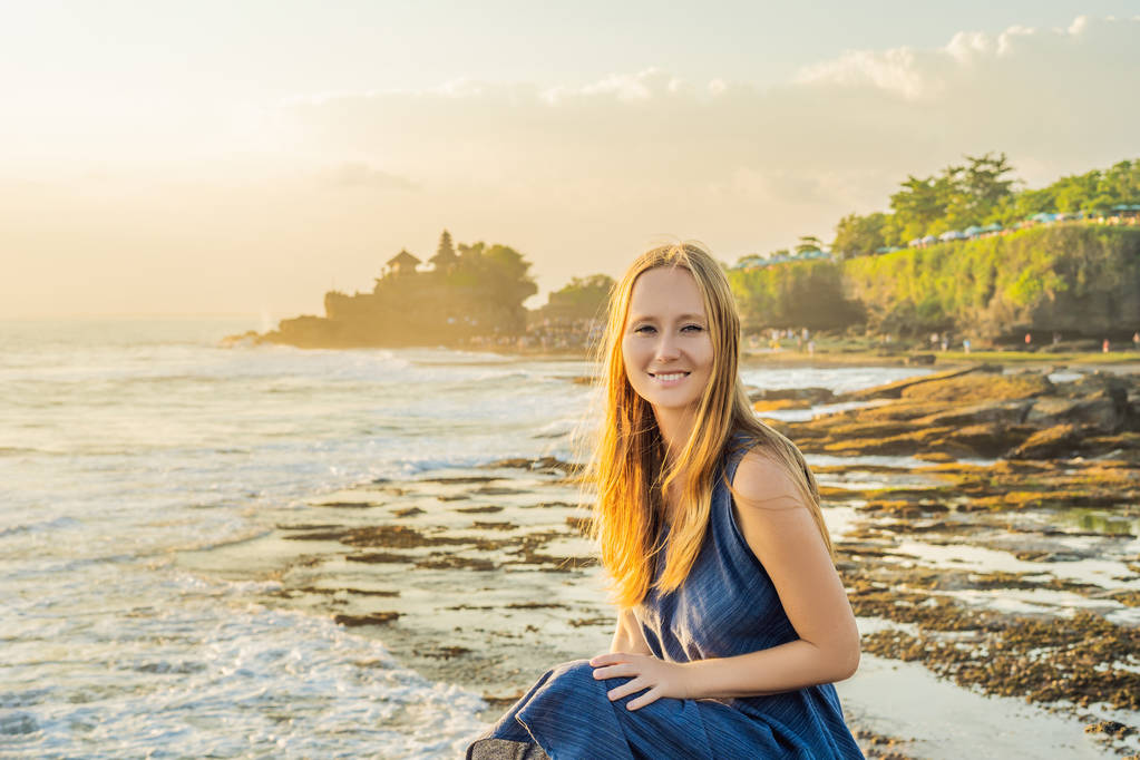 海の寺院タナロット - の背景に若い女性観光客。インドネシア ・ バリ島. - 写真・画像