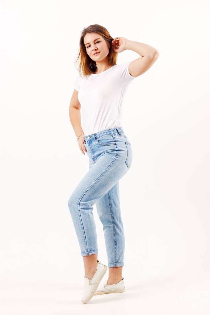 schöne Mädchen Teenager in weißem T-Shirt und Jeans posiert in weißem Studio, Ganzkörper - Foto, Bild