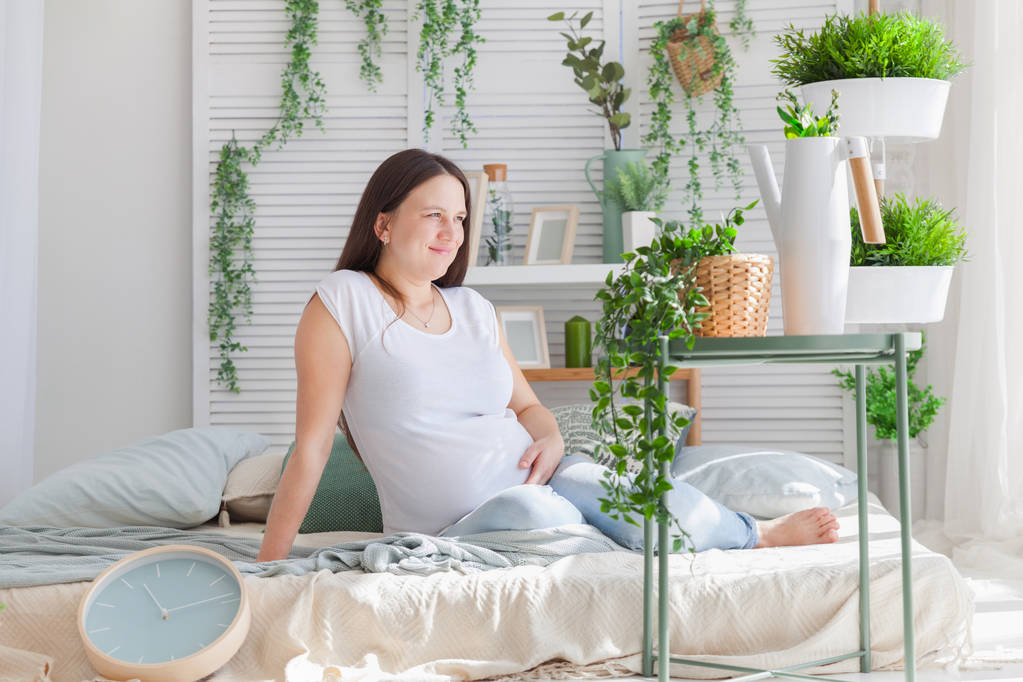 Giovane donna incinta posa in luce moderna scandinavo camera da letto interno
 - Foto, immagini