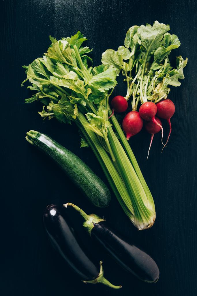 top view of celery, radishes and eggplants on grey dark table - Photo, Image