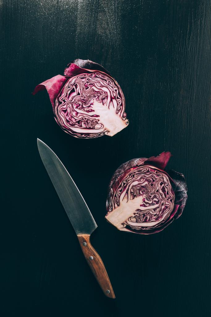 top view of cut red cabbage and knife on grey dark table - Photo, Image
