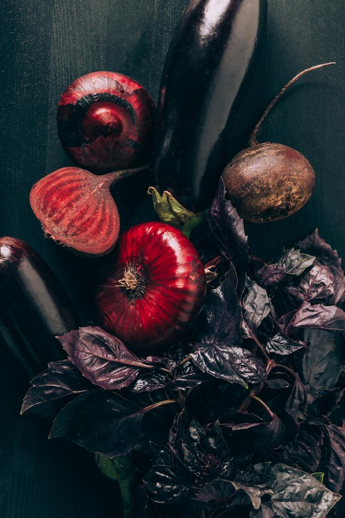 top view of basil, aubergines, onions and beetroots on grey dark table - Photo, Image