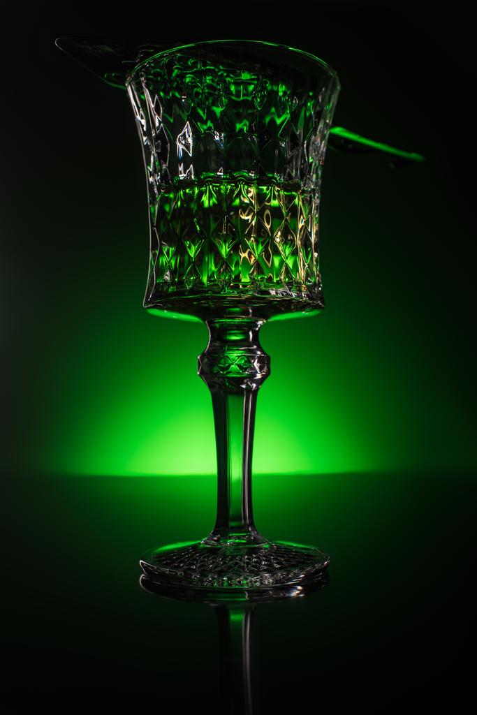 Detailní záběr skla s absintu na reflexní povrch a tmavě zelené pozadí - Fotografie, Obrázek