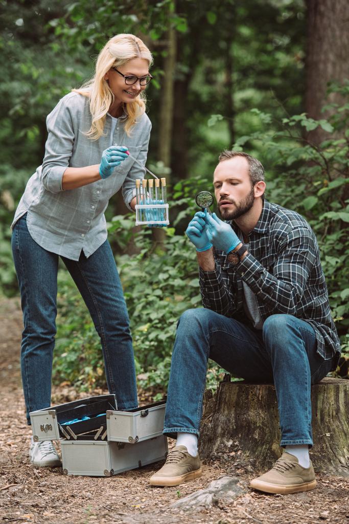 чоловіки і жінки вчені вивчають і приймають зразок сухого листа в лісі
  - Фото, зображення