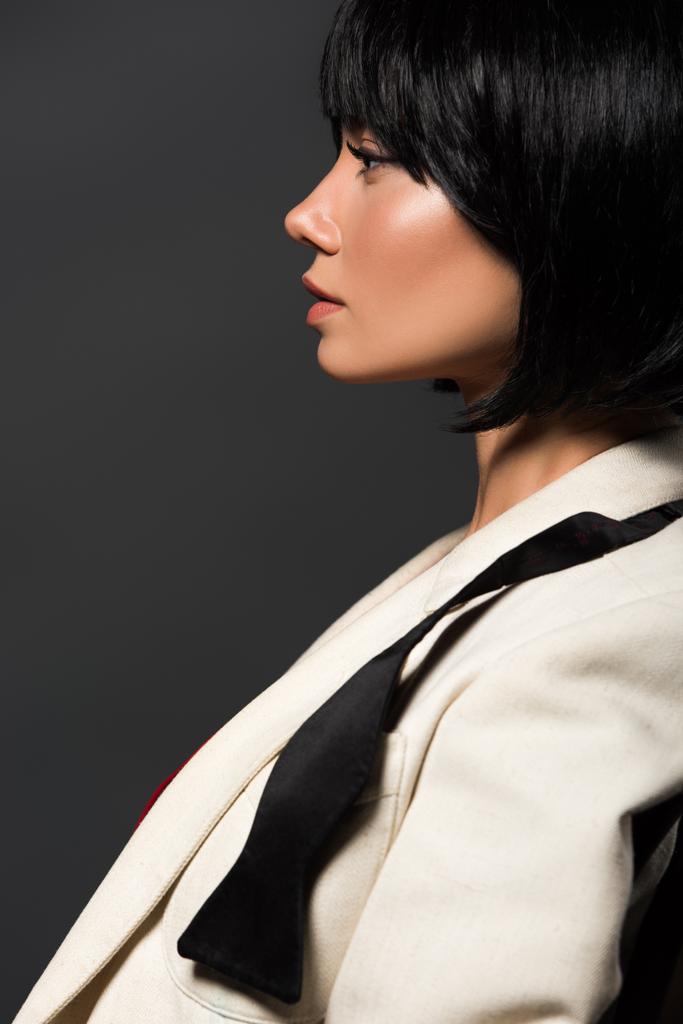 puolella näkymä houkutteleva nuori nainen tyylikäs takki ja sitomaton rusetti eristetty harmaa
 - Valokuva, kuva