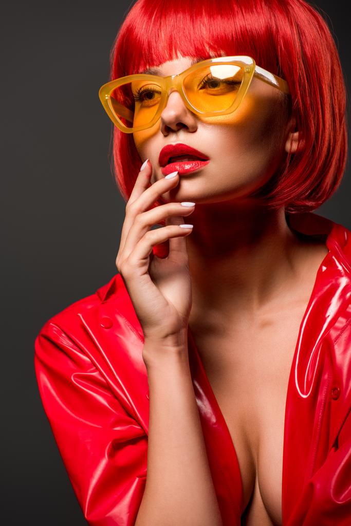 close-up retrato de bela jovem mulher em jaqueta de látex vermelho na pele nua e óculos escuros amarelos vintage isolados em cinza
 - Foto, Imagem