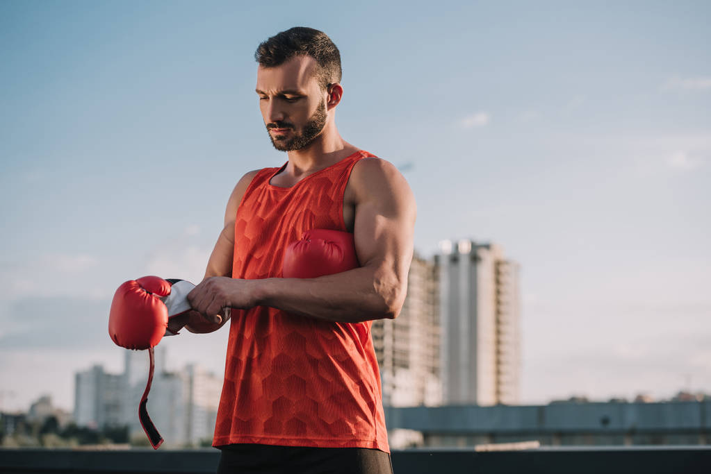 Çatıda boks eldiven giymiş yakışıklı sporcu - Fotoğraf, Görsel
