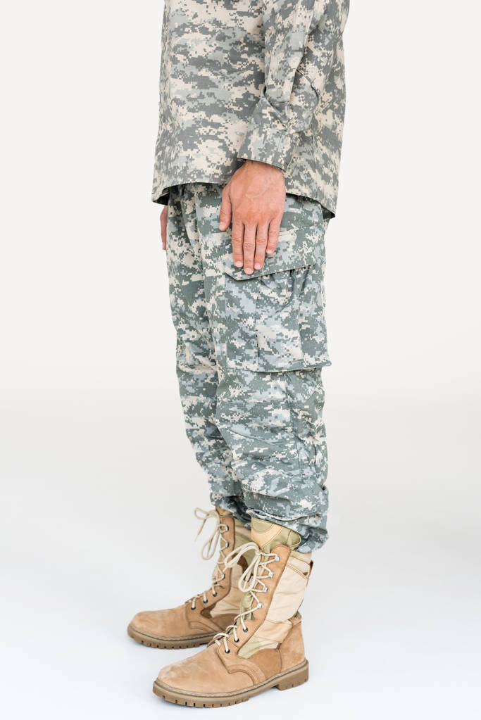 частковий вигляд чоловіка-солдата в камуфляжному одязі та чоботях на сірому фоні
 - Фото, зображення