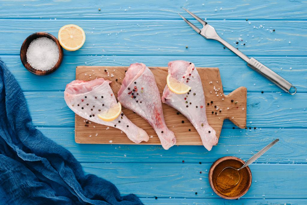 布で青い卓上の唐辛子トウモロコシで木の板に鶏の足の上から見る - 写真・画像