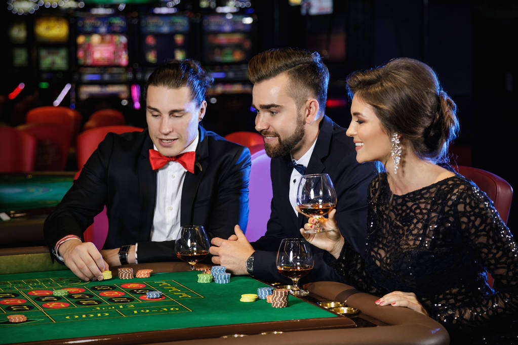 Grupo de jóvenes ricos jugando a la ruleta en el casino
 - Foto, imagen
