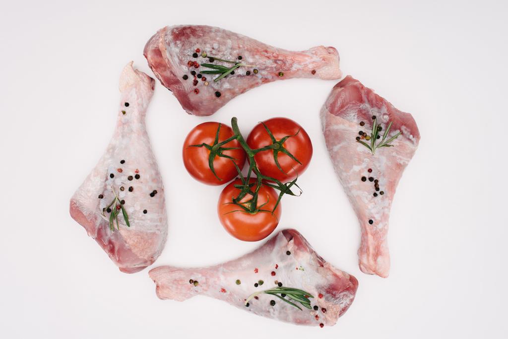 vista superior de patas de pollo y tomates cherry, aislados en blanco
 - Foto, Imagen