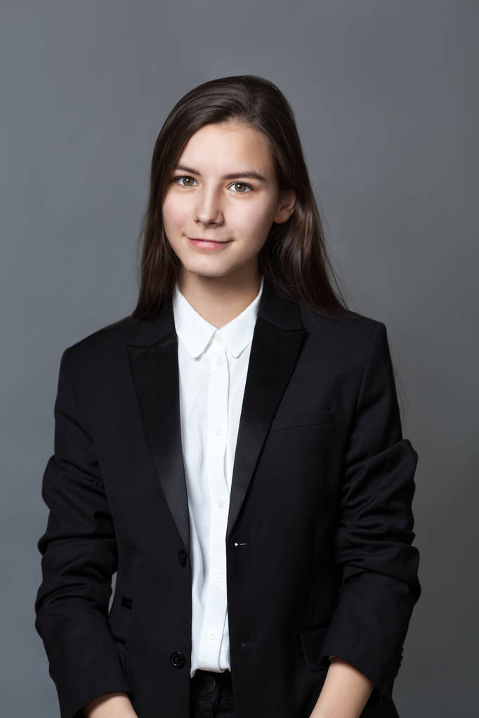 Portrét šťastný pěkná školačka teenager v bílé košili na šedém pozadí, studio - Fotografie, Obrázek