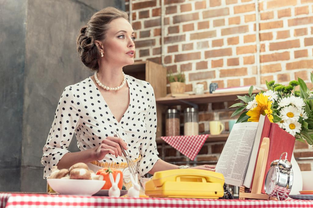 atraente adulto dona de casa cozinhar na cozinha e olhando para longe
 - Foto, Imagem