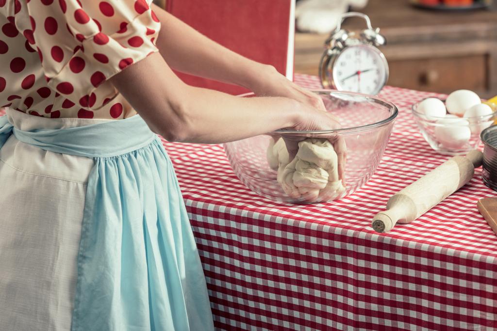 обрезанный снимок домохозяйки, готовящей тесто в стеклянной миске на кухне
 - Фото, изображение
