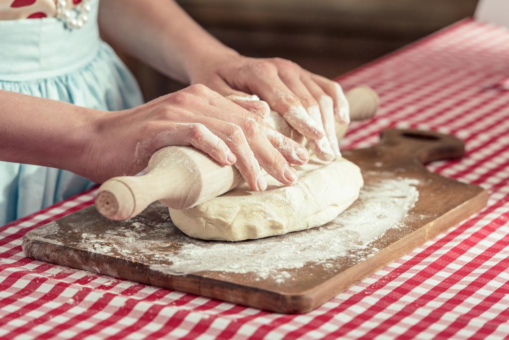 обрезанный снимок женщины, смешивающей тесто со скалкой
 - Фото, изображение