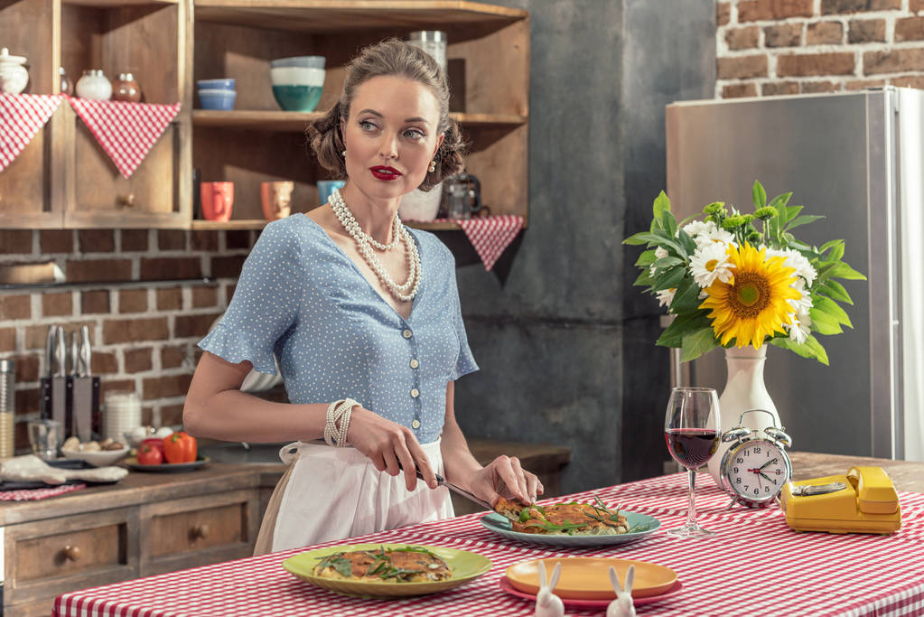 bella casalinga adulta taglio torta di funghi freschi e guardando lontano in cucina
 - Foto, immagini