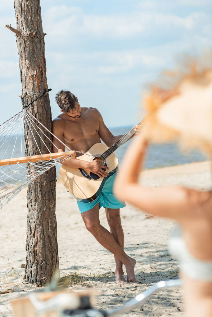 enfoque selectivo del hombre tocando la guitarra acústica con la novia en primer plano
 - Foto, imagen