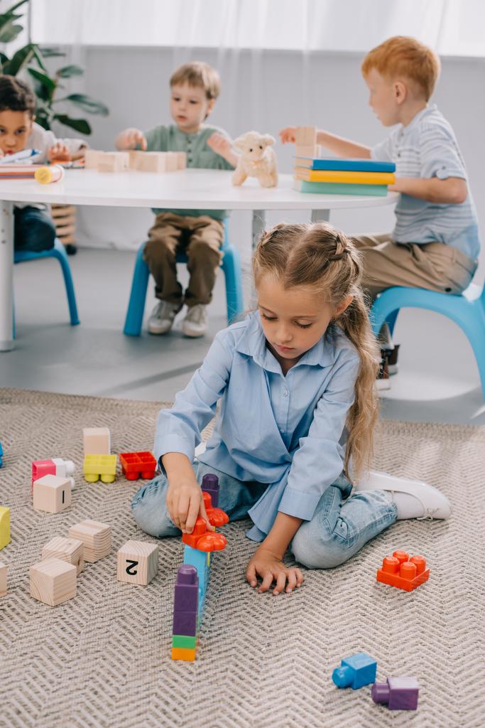 foco seletivo de pré-escolares multirraciais brincando com blocos em sala de aula
 - Foto, Imagem