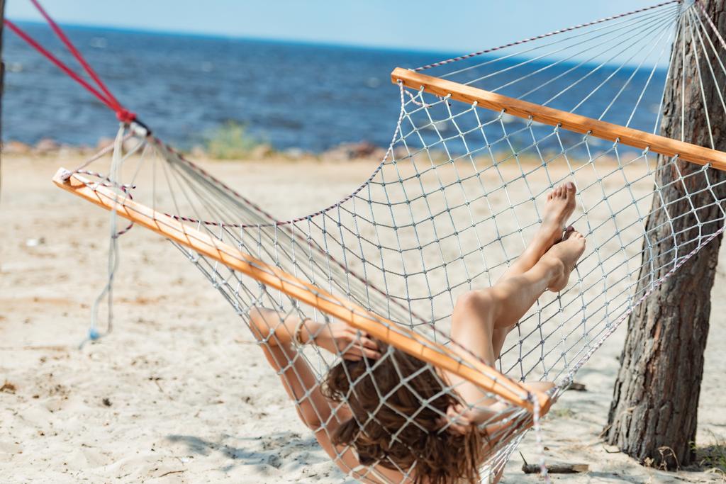 привлекательная девушка отдыхает в гамаке на пляже
 - Фото, изображение