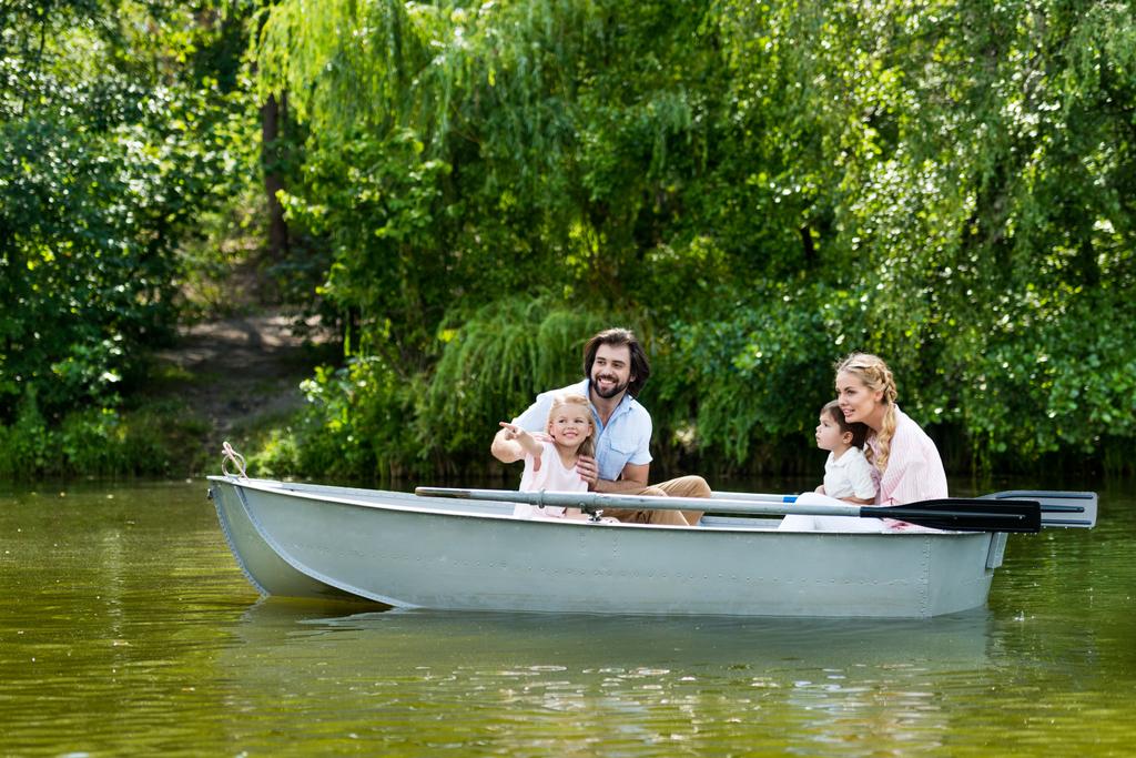 mladá rodina trávit čas spolu v lodi na řece v parku a hledat dál - Fotografie, Obrázek