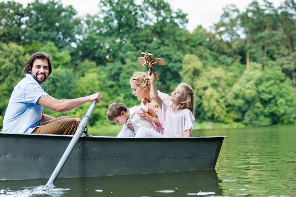 heureux jeune famille équitation bateau sur le lac au parc ensemble
 - Photo, image