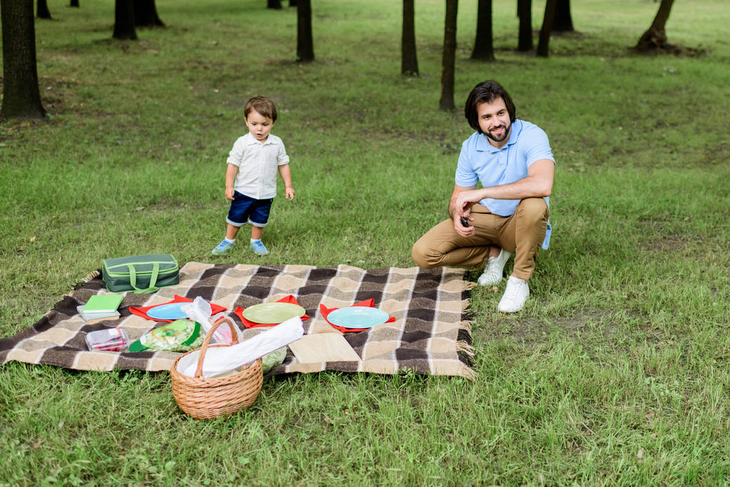 szép boldog apa és kis fia, miután a piknik Park - Fotó, kép