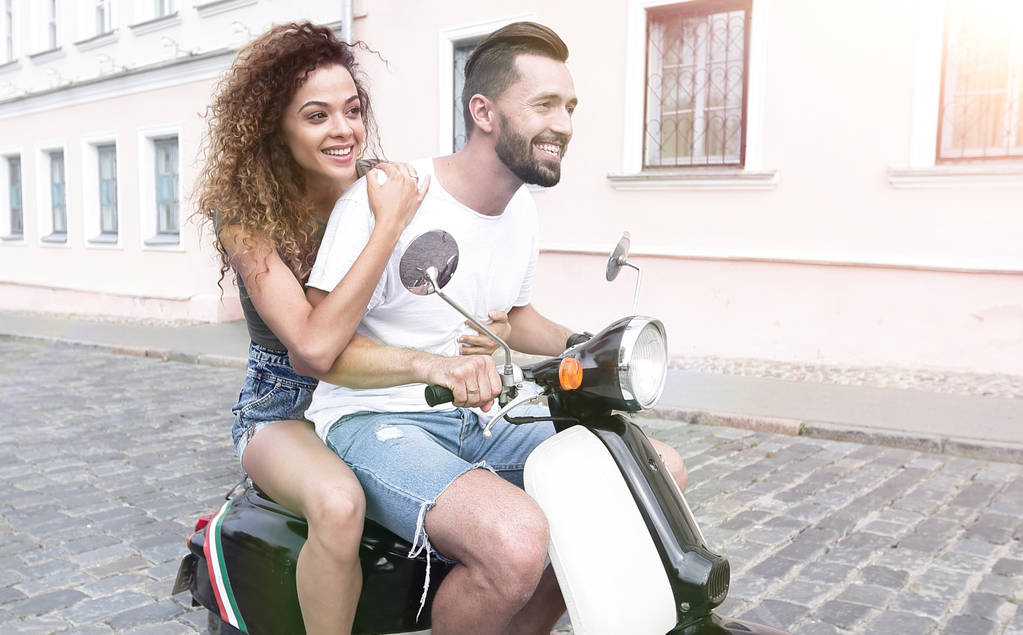 Seitenansicht eines glücklichen Paares auf einem Retro-Motorrad in voller Länge - Foto, Bild