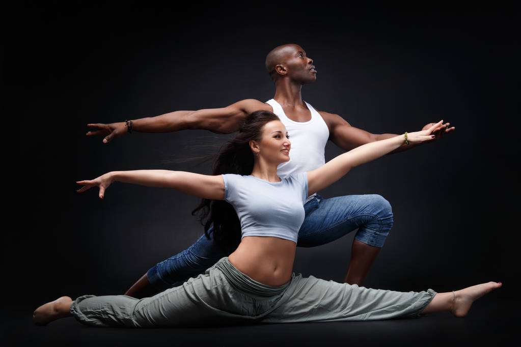 Черный мужчина и белая женщина в красивой танцевальной позиции на черном фоне
. - Фото, изображение