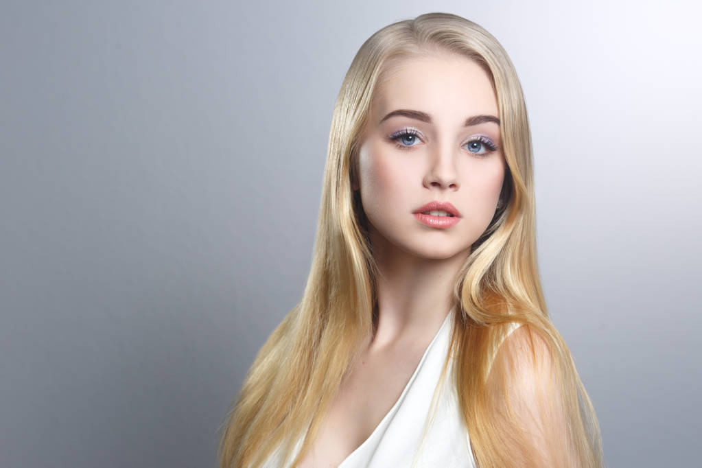 Kauneus muotokuva söpö blondi pitkät suorat hiukset eristetty hoidettu harmaalla pohjalla
. - Valokuva, kuva