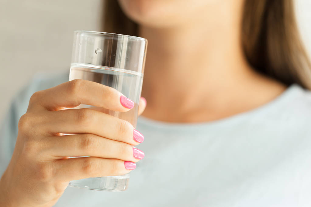 Vrouw met een glas water, close-up - Foto, afbeelding