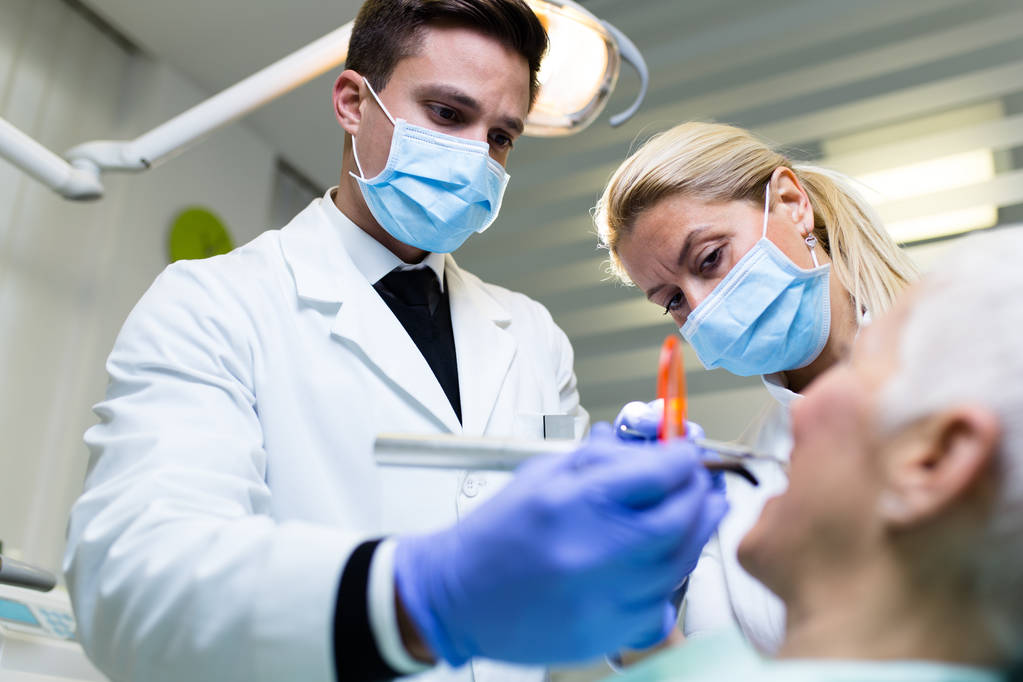 οδοντίατρος και ασθενής στην οδοντιατρική κλινική - Φωτογραφία, εικόνα