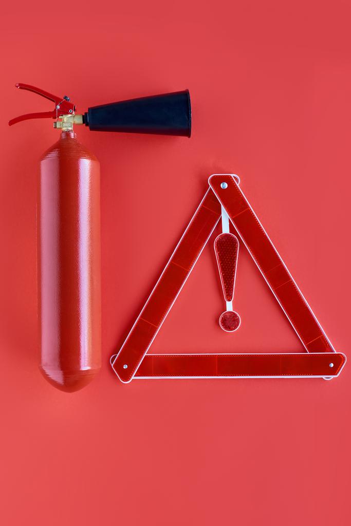 top view of fire extinguisher and warning triangle isolated on red - Photo, Image