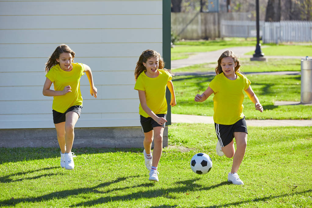 Przyjaciel dziewczyny nastolatki gry piłka nożna na żywo w parku darń trawy - Zdjęcie, obraz