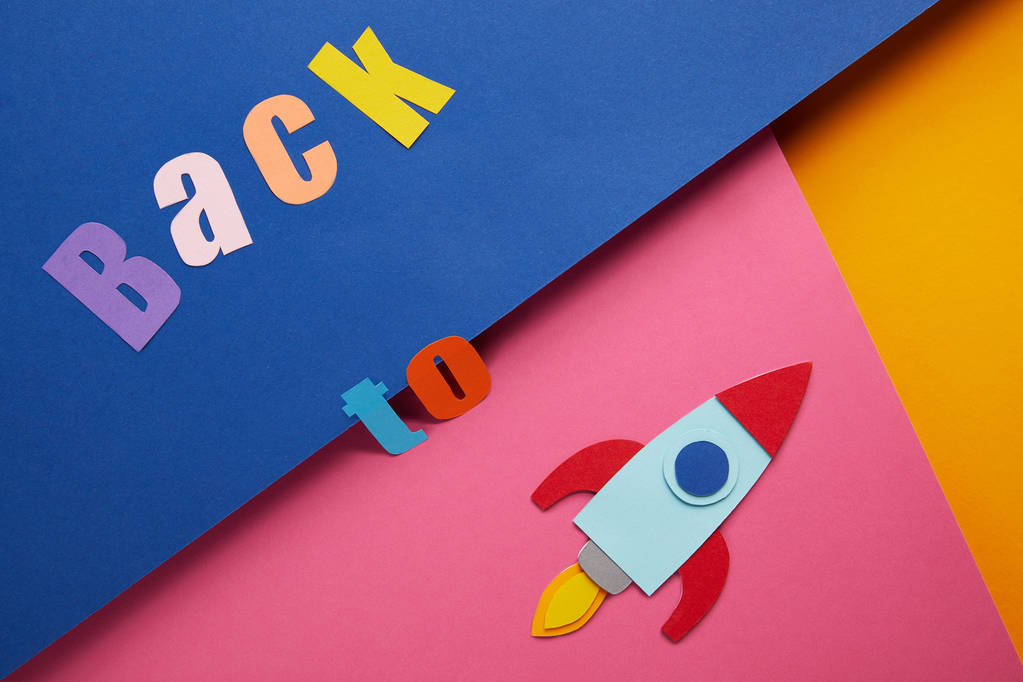 flache Liege mit "Rücken zu" Schriftzug und Rakete auf buntem Papierhintergrund - Foto, Bild