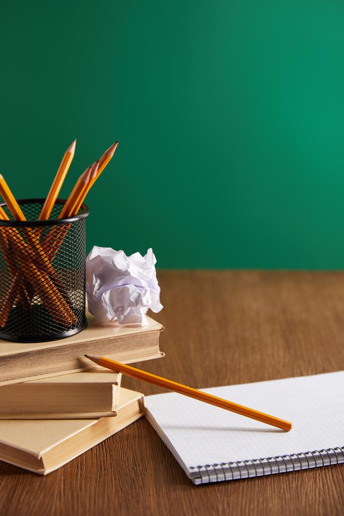 книги, тетрадь, бумага и карандаши на деревянном столе
 - Фото, изображение