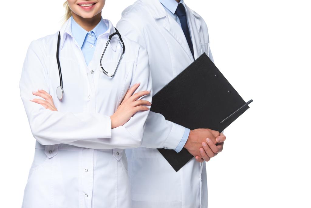 περικομμένη εικόνα των ιατρών που στέκεται με στηθοσκόπιο και πρόχειρο απομονωθεί σε λευκό - Φωτογραφία, εικόνα