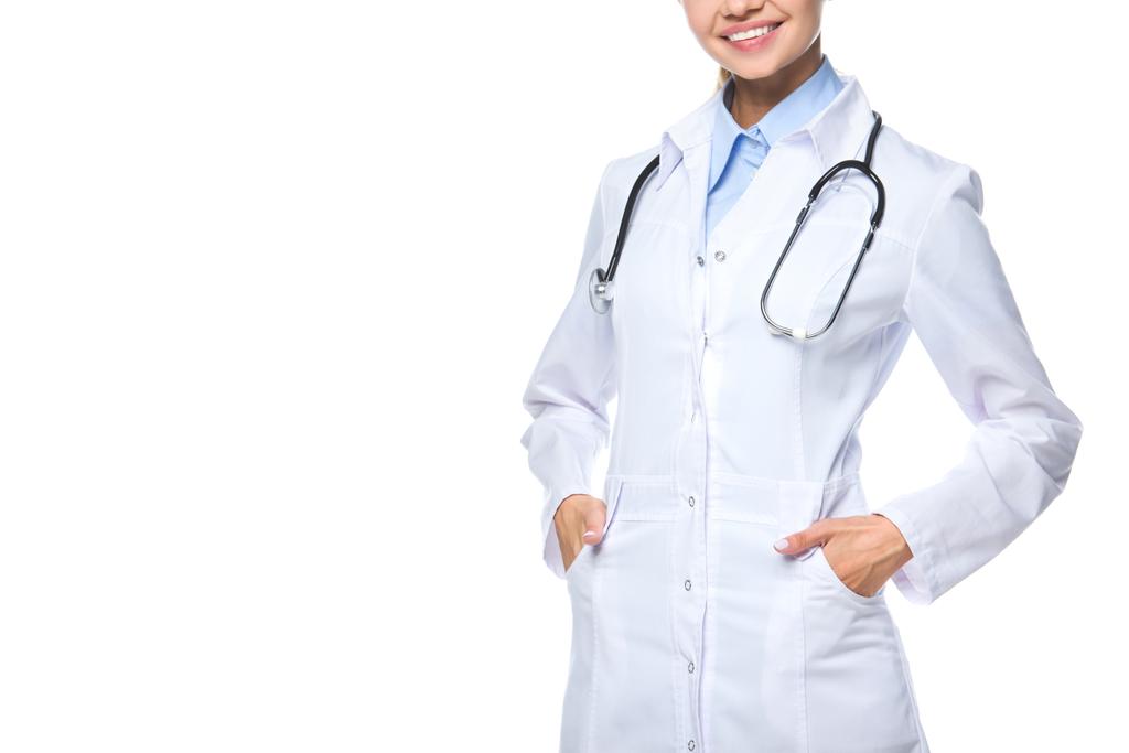 обрезанный вид улыбающегося доктора, позирующего в белом халате со стетоскопом, изолированного на белом
 - Фото, изображение