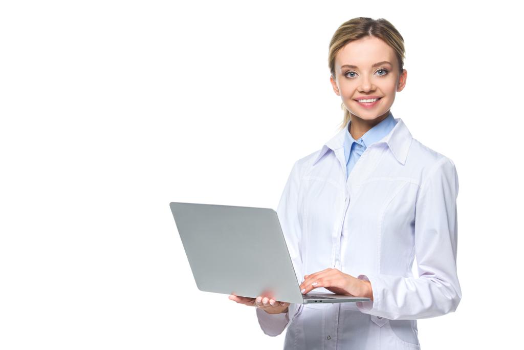 молодий усміхнений лікар у білому пальто тримає ноутбук, ізольований на білому
 - Фото, зображення
